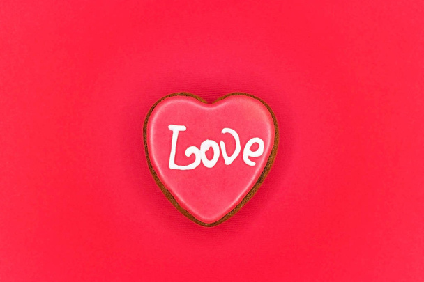 ハート型の赤い背景の上のクッキー。木製の背景に対してスタンドのバレンタイン クッキー - 写真・画像