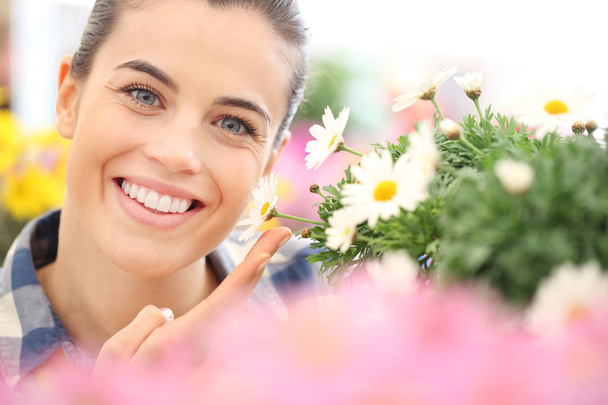 Jarní koncept, usmívající se žena v zahradě květů sedmikrásky - Fotografie, Obrázek