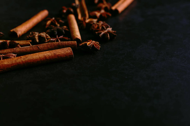 Spices sticks cinnamon and star anise on old table. Rustic dark background, aroma close-up, macro. - Photo, image