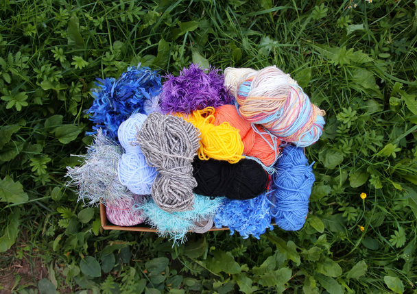 Skeins of bright woolen yarn oon green grass - Fotografie, Obrázek