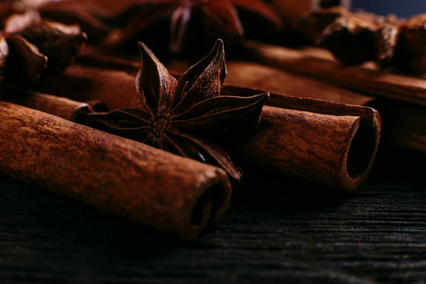 Spices sticks cinnamon and star anise on old table. Rustic dark background, aroma close-up, macro. - 写真・画像