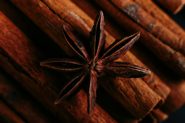 Spices sticks cinnamon and star anise on old table. Rustic dark background, aroma close-up, macro. - Fotoğraf, Görsel