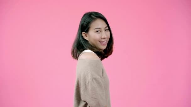 Smiling adorable Asian female with positive expression, smiles broadly, dressed in casual clothing and looking at the camera over pink background. Happy adorable glad woman rejoices success. - Video