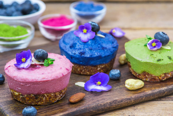 healthy vegan desserts. assortment of raw cashew cakes with matcha, acai, blueberry, mint and nuts. gluten free diet. close up - Photo, Image