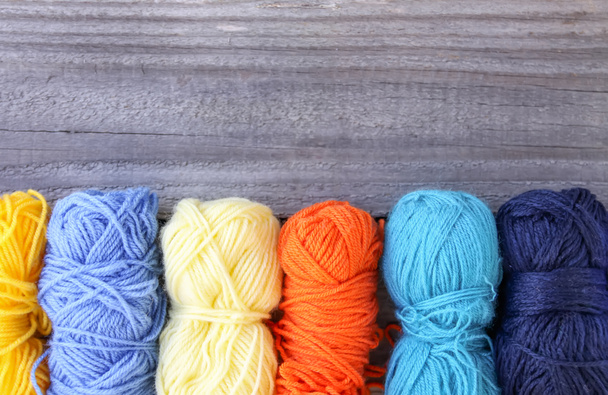Colorful yarn skeins on rough wooden background - Foto, immagini