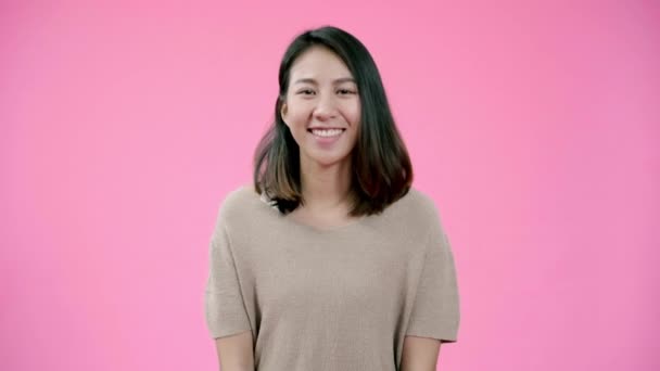 Smiling adorable Asian female with positive expression, smiles broadly, dressed in casual clothing and looking at the camera over pink background. Happy adorable glad woman rejoices success. - 映像、動画