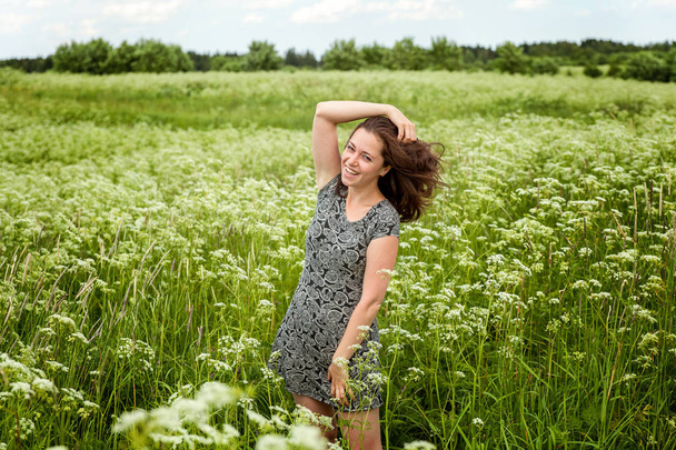 Beauty Girl Outdoors enjoying nature. Beautiful woman jumping on summer Field with blooming wild flowers, Sun Light. Free Happy Woman - Photo, Image