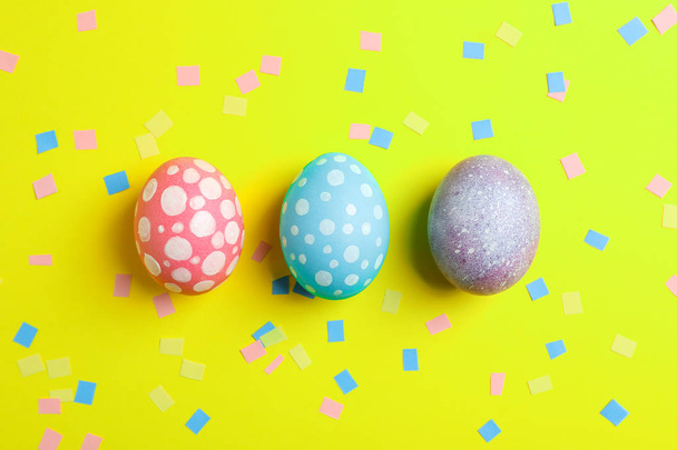 Huevos de Pascua decorativos sobre fondo de color, espacio para texto. Vista superior
 - Foto, Imagen