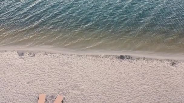 Vista aérea de dos tumbonas empy en la playa de arena
 - Metraje, vídeo