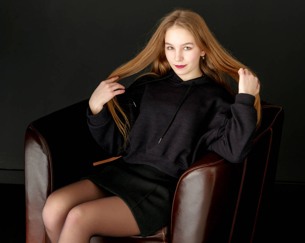 Fashionable girl teenager studio photo on a black background. - Fotoğraf, Görsel
