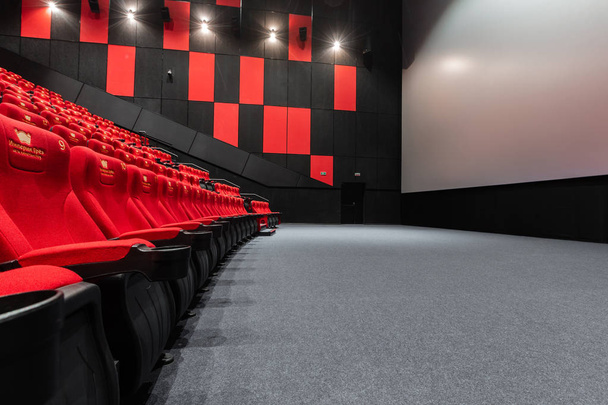 Rusia, Nizhny Novgorod - 14 de noviembre de 2016: Cinema Imperia Grez Nebo, Dolby Atmos. Asientos de sala de cine rojo vacíos, sillas cómodas y suaves. Vista panorámica del auditorio con espacio en blanco en la pantalla
 - Foto, imagen