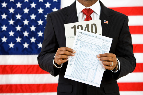Politician: Holding Up the US Income Tax Form - Foto, Imagen