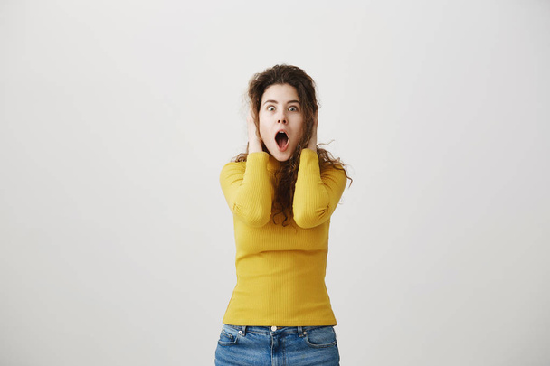 Portrait excited screaming young woman standing isolated over white background. Looking camera. - Foto, immagini