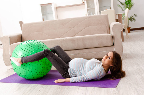 Young pregnant woman doing sport exercises at home  - Foto, Imagem