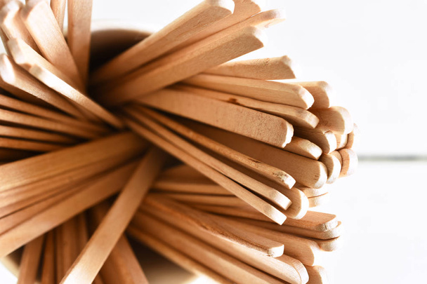 Een close-up beeld van verschillende houten roer stokken in een wegwerp koffiekopje.  - Foto, afbeelding