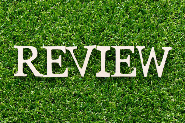 Dřevěná abeceda v aplikaci word recenzi na umělé trávě zelené pozadí - Fotografie, Obrázek