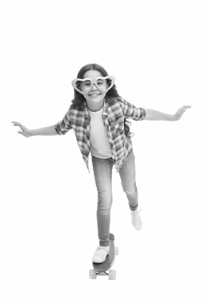 Kid happy lovely feels sympathy. Child charming smile fall in love. Girl heart shaped eyeglasses rides penny board. Girl playful cute smiling face heart glasses. Love runs world. Childhood love - Foto, afbeelding