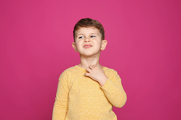 Little boy scratching neck on color background. Annoying itch - Fotoğraf, Görsel