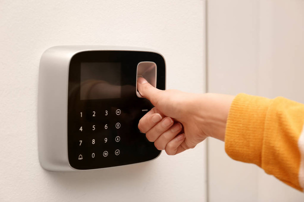 Woman scanning fingerprint on alarm system indoors, closeup - Photo, image
