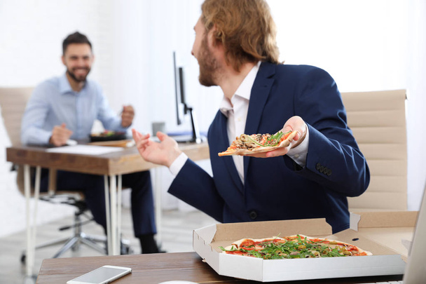 Office employees having lunch at workplace. Food delivery - Foto, imagen