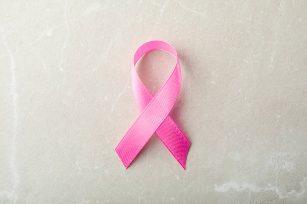 Pink ribbon on grey background, top view. Breast cancer awareness concept - Photo, Image