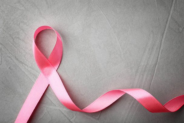 Pink ribbon on grey background, top view with space for text. Breast cancer awareness concept - Foto, immagini