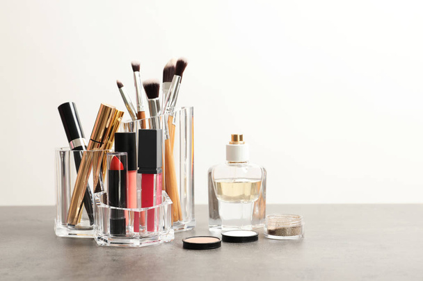 Lipstick holder with different makeup products on table against white background. Space for text - Zdjęcie, obraz