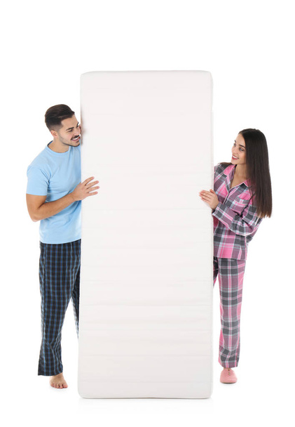 Young couple with comfortable mattress isolated on white - Fotoğraf, Görsel