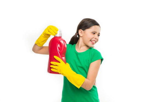 A washing day. Little child ready for household laundering. Small child holding laundry detergent in hands. Using household cleaning product. Adorable little cleaner wearing yellow rubber gloves - Foto, Imagen
