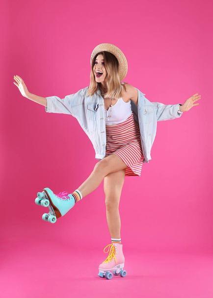Young woman with retro roller skates on color background - Foto, Imagen