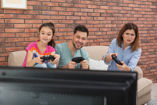 Happy family playing video games in living room - 写真・画像