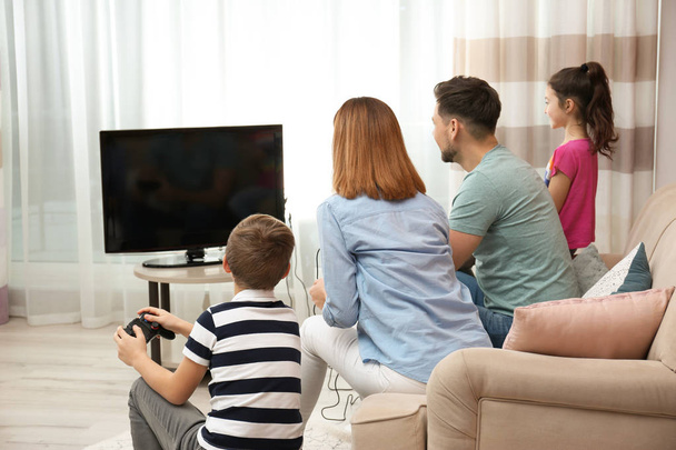 Happy family playing video games in living room - Fotó, kép
