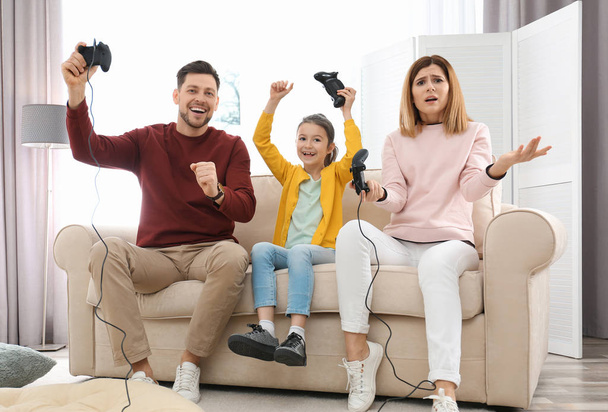 Família feliz jogando jogos de vídeo na sala de estar
 - Foto, Imagem