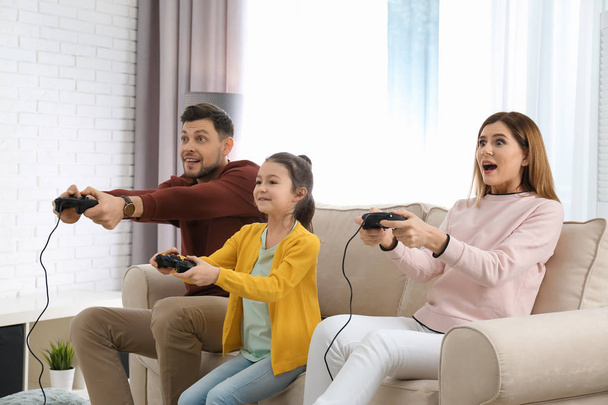 Happy family playing video games in living room - Photo, image