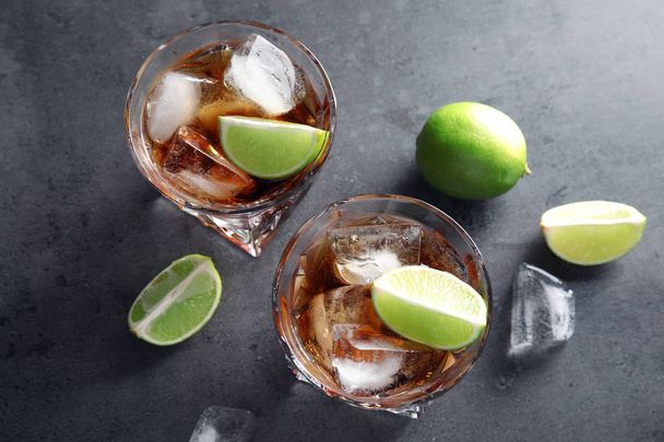 Glasses of refreshing drink with ice cubes and lime on table, top view - Foto, afbeelding