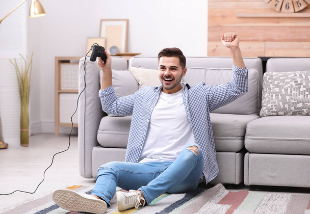 Emotional young man playing video games at home - Foto, Imagem