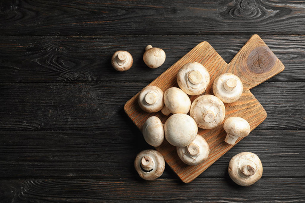Flat lay composition with fresh champignon mushrooms on wooden table. Space for text - Fotoğraf, Görsel