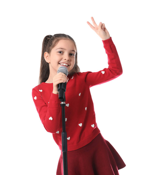 Little girl singing into microphone on white background - Фото, изображение