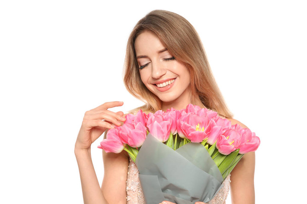 Portrait of smiling young girl with beautiful tulips on white background. International Women's Day - Φωτογραφία, εικόνα
