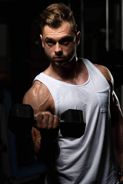 Sportowiec ćwiczący bicepsy w siłowni - hantle Concentration Loki - Zdjęcie, obraz
