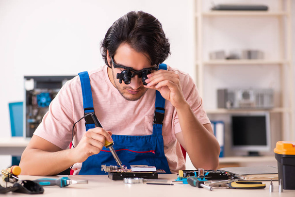 Молодой мужчина-подрядчик ремонта компьютера   - Фото, изображение
