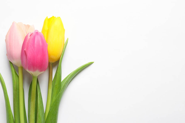 Beautiful spring tulips on white background, top view. International Women's Day - Foto, Imagem