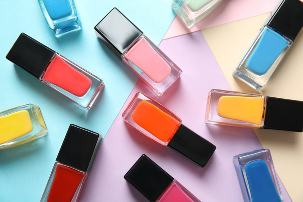 Bottles of nail polish on color background, top view - Fotografie, Obrázek