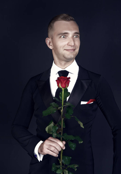 Ballroom dancer smile with red rose on dark background - Foto, Imagem