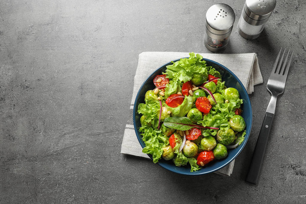 Salad with Brussels sprouts served on grey table, flat lay. Space for text - Foto, Imagen