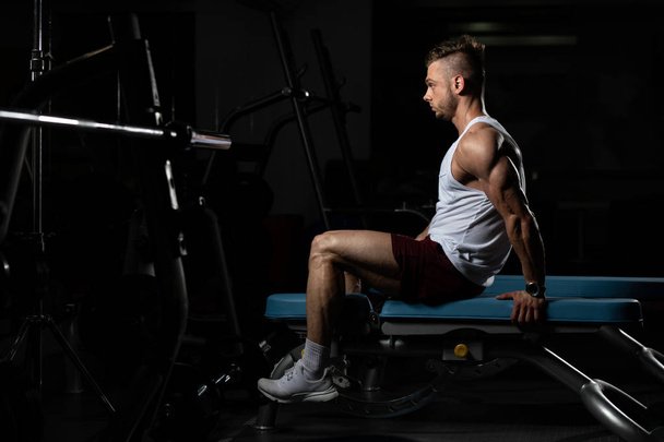 Attractive Man Resting On Bench After Exercise In Fitness Center - Foto, afbeelding