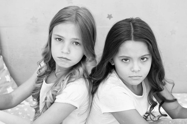 Offended feelings. Children offended keep silence. Relations sisters or best friends. Overcome relations issues. Childhood friendship. Friends sit back to back. Offended kids look seriously and sadly - Photo, image