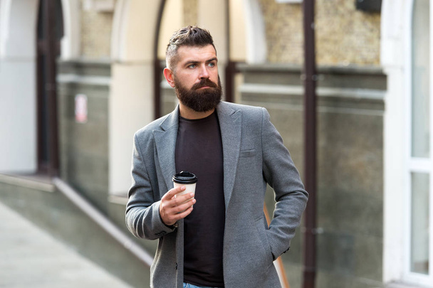 Man bearded hipster drinking coffee paper cup. One more sip of coffee. Drinking coffee on the go. Businessman lumbersexual appearance enjoy coffee break out of business center. Relax and recharge - 写真・画像