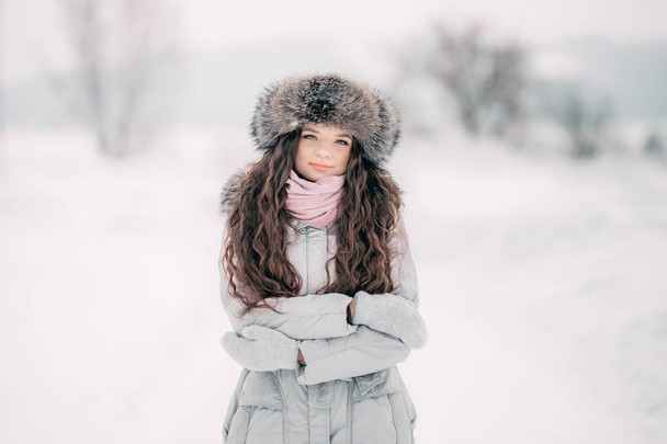 retrato de bela fêmea sorridente em luxuoso pano de cabeça de pele ao ar livre no inverno cabelo longo
 - Foto, Imagem