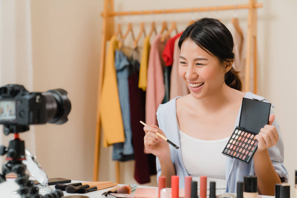 Beauty-Blogger präsentieren Schönheitskosmetik, die vor der Kamera sitzt, um Videos aufzunehmen. schöne asiatische Frau verwenden Kosmetika Bewertung Make-up-Tutorial übertragen Live-Video auf soziale Netzwerke über das Internet. - Foto, Bild